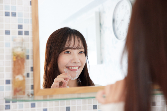 マウスピースで歯列矯正をする女性