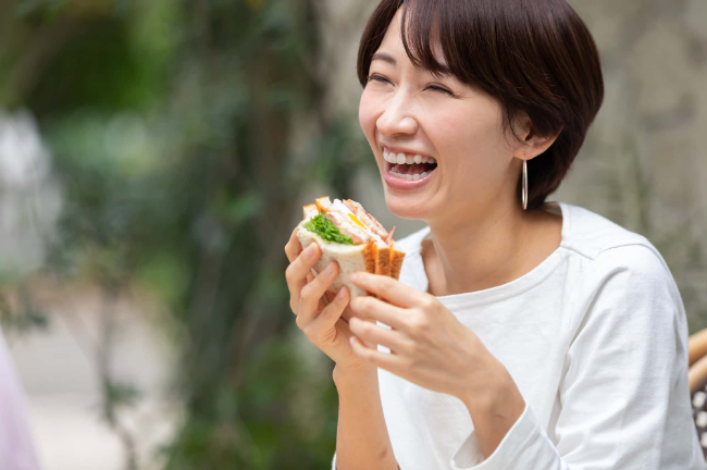 横向きに生えた親知らずを抜歯して快適に食事をする女性
