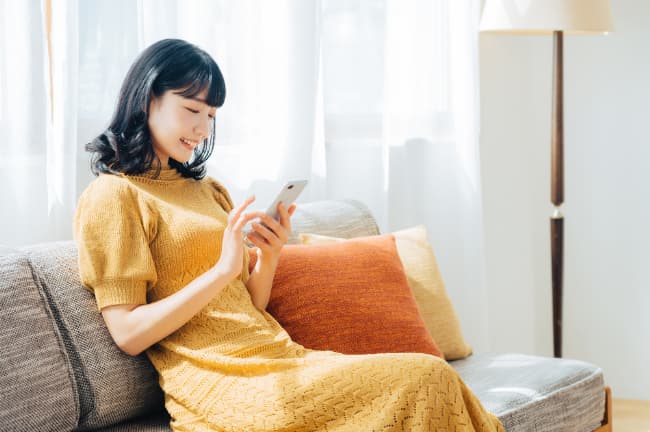 審美歯科治療にはどんな方法があるのかスマホで調べる女性