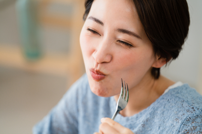 奥歯をインプラントにして食事をする女性