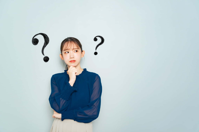 歯医者で行うホワイトニングはどうして高額なのか考える女性